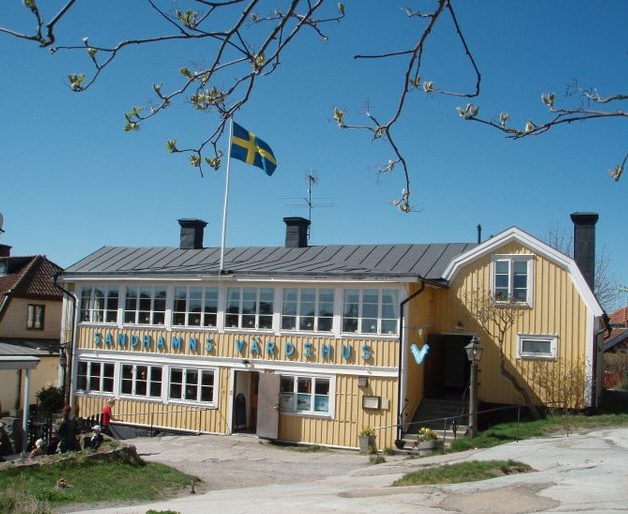 Sandhamns värdshus gult stort hus med vita knutar och blå himmel